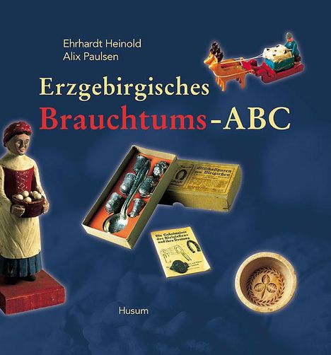 Text: "Ehrhardt Heinold Alix Paulsen Erzgebirgisches Brauchtums-ABC Husum." Zu sehen sind traditionelle erzgebirgische Figuren und Holzarbeiten.