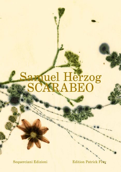 "Samuel Herzog SCARABEO" in goldener Schrift, mit Blüten und Blättern auf hellem Hintergrund.