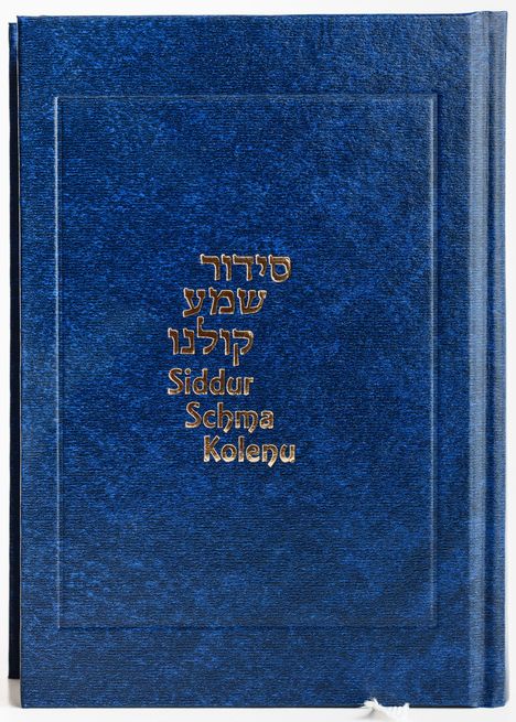 Der Text lautet: "Siddur Schma Kolenu". Es ist ein dunkelblaues Buch mit goldener Schrift.