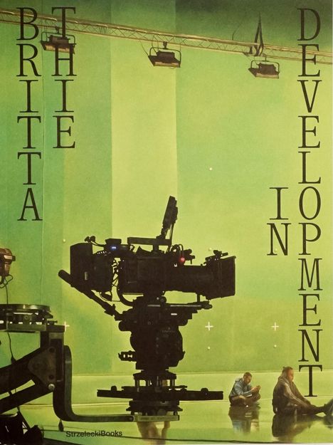 "Brittathe in Development" steht in großen, senkrechten Buchstaben. Szene mit einem großen, professionellen Kamerasystem.