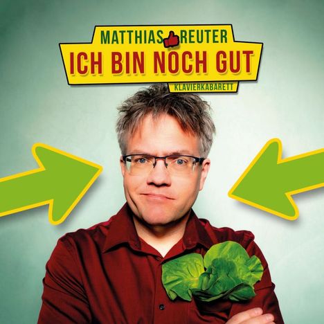 Matthias Reuter, Ich bin noch gut, Klavierkabarett. Ein Mann mit Brille, rotes Hemd, grünem Salat und zwei grünen Pfeilen.