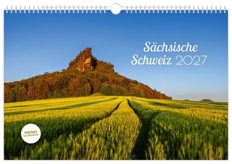"Sächsische Schweiz 2027" oben in Weiß. Eine grüne Wiese, im Hintergrund ein bewaldeter Hügel bei Sonnenuntergang.