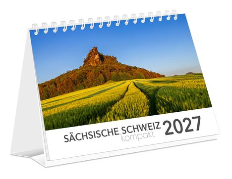 "Sächsische Schweiz kompakt 2027." Spiralkalender mit Landschaft: Feld und Hügel unter blauem Himmel.