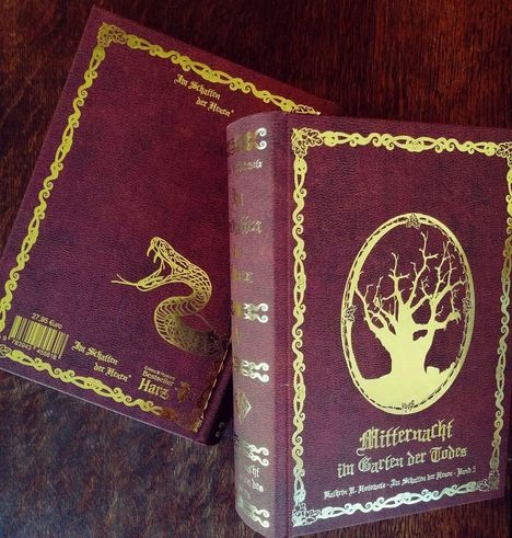 Zwei Bücher mit goldenen Verzierungen, eines zeigt eine Schlange, das andere einen Baum mit "Mitternacht im Garten der Tode".