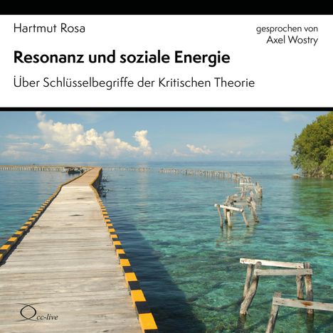 "Resonanz und soziale Energie" gegen Himmel und Meer. Ein langer Holzsteg führt über klares Wasser mit Holzpfählen.