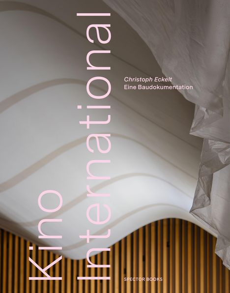 „Kino International“ steht vertikal. Das Bild zeigt wellenförmige, weiße und braune architektonische Strukturen.