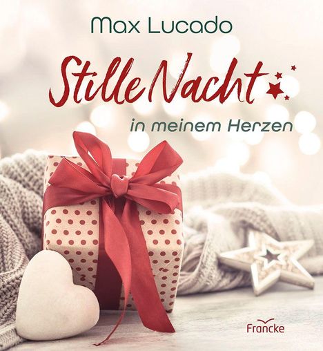 "Max Lucado. Stille Nacht in meinem Herzen. Francke." Ein Geschenk mit roter Schleife, Herz und Stern auf hellem Hintergrund.