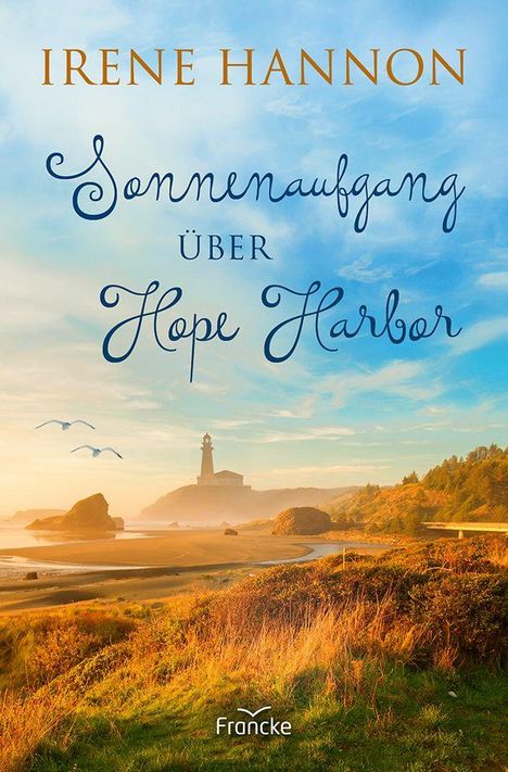 „Irene Hannon: Sonnenaufgang über Hope Harbor.“ Illustration eines malerischen Strands mit Leuchtturm bei Sonnenaufgang.
