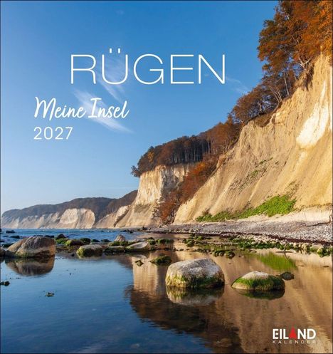 „Rügen, Meine Insel 2027“. Steilküste mit Bäumen, großer Strand und Felsen im Wasser, EILAND KALENDER Logo unten rechts.