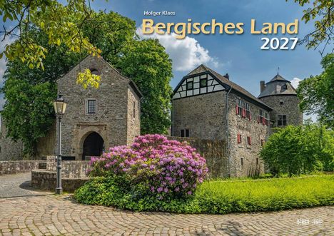 "Holger Klaes Bergisches Land 2027" steht zentral. Historische Gebäude, blühender Rhododendron und Kopfsteinpflaster.