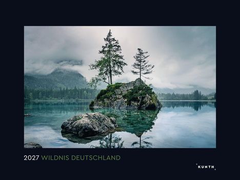 2027 WILDNIS DEUTSCHLAND. Ein stiller See mit Bäumen auf einem Felsen und nebelverhangenen Bergen im Hintergrund.