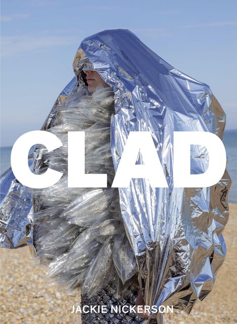 Großer weißer Text "CLAD" und unten "JACKIE NICKERSON". Person in metallischer Folie am Strand.