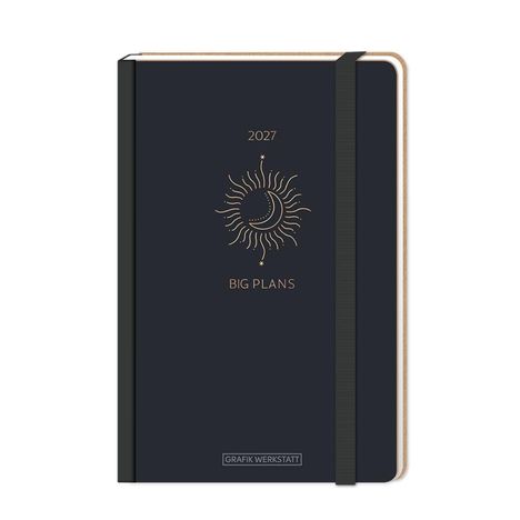 2027, BIG PLANS. Ein schwarzes Notizbuch mit einem goldenen Sonnensymbol und elastischem Band.
