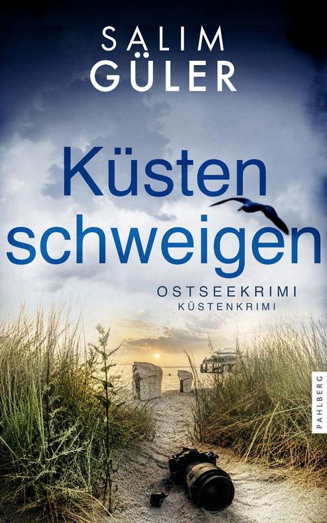 „Küsten schweigen“, Salim Güler, Ostseekrimi. Ein Strandpfad führt zwischen Dünen zu Strandkörben am Meer bei Sonnenuntergang.