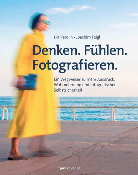 "Denken. Fühlen. Fotografieren." Eines der Texte oben. Verschwommene Person in Gelb, Meer im Hintergrund, blauer Himmel.