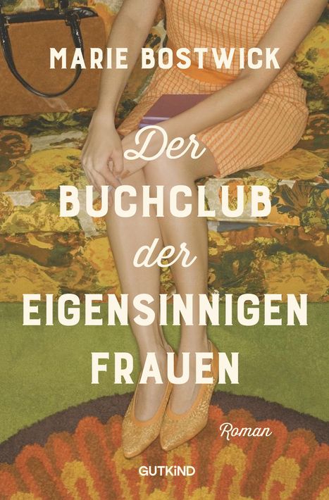 Text: "Marie Bostwick. Der Buchclub der eigensinnigen Frauen. Roman. GUTKIND." Frau in orangefarbenem Kleid, sitzend.