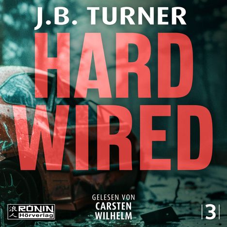 Text: "J.B. Turner HARD WIRED" in großen roten Buchstaben. Unten: "Gelesen von Carsten Wilhelm". Ein beschädigtes rotes Auto.