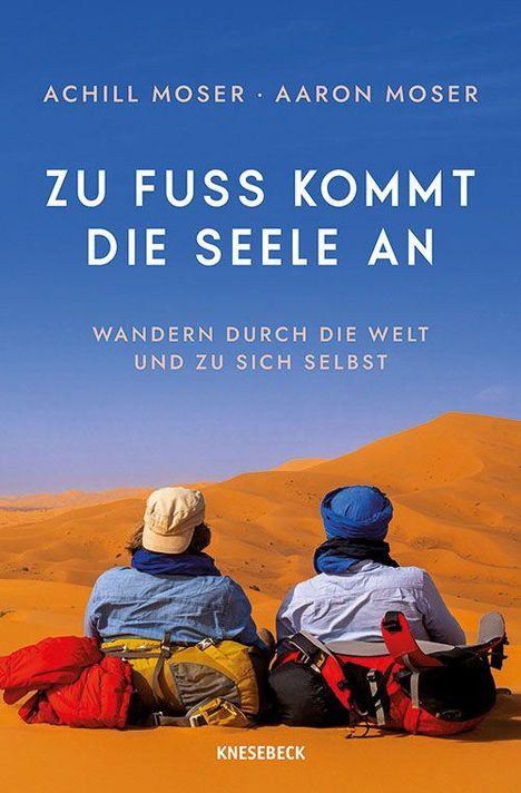 "Zu Fuß kommt die Seele an. Wandern durch die Welt und zu sich selbst." Zwei Personen sitzen in einer Wüstenlandschaft.