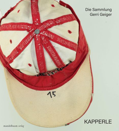 Die Sammlung Gerri Geiger. Eine rote und beige Kappe, oben die Zahl "15". Text auf rotem Streifen: "Sutterheim".