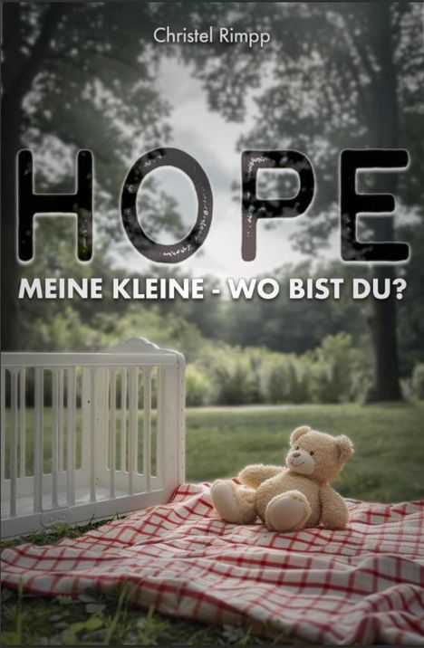 „HOPE MEINE KLEINE - WO BIST DU?“ Ein Teddybär sitzt auf einer rot-weiß karierten Decke im Freien neben einem Gitter.