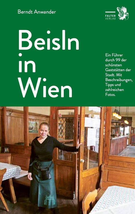 „Beisln in Wien“ – Ein Restaurantführer. Eine Frau steht lächelnd in einem traditionellen Lokal mit Holzinterieur.