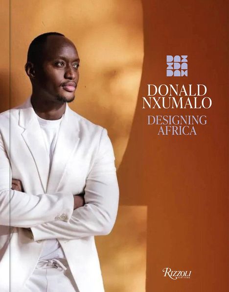 DONALD NXUMALO DESIGNING AFRICA. Ein Mann in weißem Anzug vor einer orange-braunen Wand.