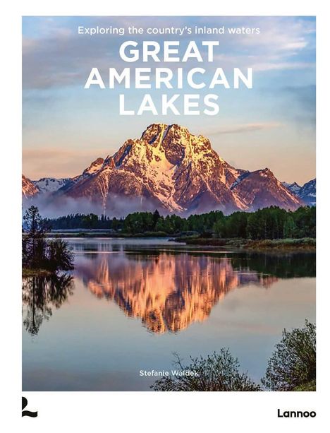 "Exploring the country’s inland waters. GREAT AMERICAN LAKES. Stefanie Waldek. Ein schneebedeckter Berg spiegelt sich in einem ruhigen See."
