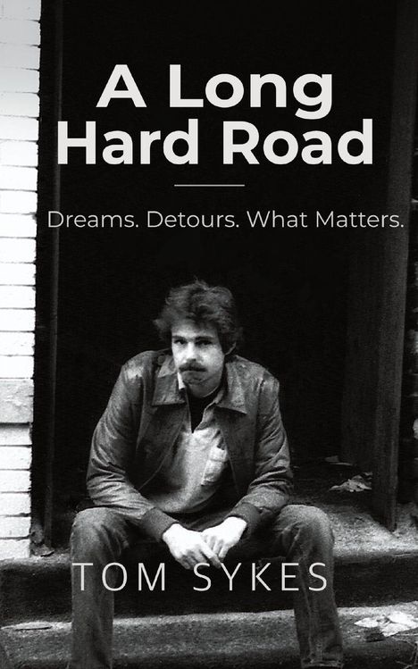 "A Long Hard Road. Dreams. Detours. What Matters. Tom Sykes." Schwarz-weißes Foto eines Mannes auf einer Treppe.