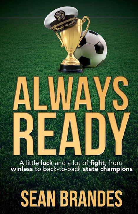 Titel: ALWAYS READY. Untertitel: A little luck and a lot of fight, from winless to back-to-back state champions. Autor: SEAN BRANDES. Im Hintergrund: Ein Pokal, ein Fußball und eine Offiziersmütze auf einem Fußballfeld.