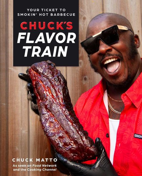 "Chuck's Flavor Train" steht groß auf einem Schild. Ein lachender Mann in rotem Hemd hält ein gegrilltes Fleischstück.