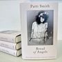 Auf dem Buchcover steht: "Patti Smith, Bread of Angels, Die Geschichte meines Lebens". Schwarz-weiß Foto einer Frau mit Blumenkranz.