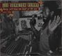 Text: "Lee 'Scratch' Perry, Crucial Cuts from the Heart of the Ark (1973-1978)." Schwarzer Mann an einem Mischpult mit erhobenen Händen.