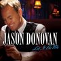 "Jason Donovan" und "Let It Be Me" stehen vorne. Ein Mann lächelt, sitzt in einem warm beleuchteten Raum.