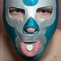 Ein Herz mit der Aufschrift "NEW SELF" auf der Zunge einer Person mit silber-blauer Maske.