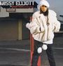 „MISSY ELLIOTT // GOSSIP FOLKS featuring LUDACRIS.“ Frau in weißem Pelzmantel und Mütze, urbaner Hintergrund.