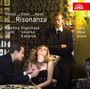 Text: "Hanuš Eben Haas Risonanza. Kateřina Englichová, Vilém Veverka, Ivo Kahánek. Harp, oboe, piano."

Szene: Edler Raum, eine Frau sitzt entspannt, ein Mann richtet ihren Schmuck, ein anderer steht daneben.