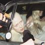 Eine Person mit blonden Haaren schaut aus einem Autofenster; Mikrofone sind darauf gerichtet.