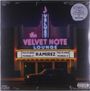 "VELVET NOTE LOUNGE", "RAMIREZ". Gebäude im Neonlicht, Auto davor.