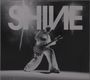 Der Text "SHINE" ist groß und markant. Unten ist eine Person in weiß, die eine Gitarre mit auffälligem Muster spielt.