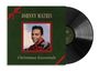 "JOHNNY MATHIS" oben, "Christmas Essentials" unten. Porträt von Mann in rotem Rahmen. Schwarze Schallplatte rechts.