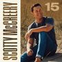 "SCOTTY McCREERY" steht links senkrecht, große "15" oben rechts. Ein Mann sitzt lächelnd in Grasdünen.