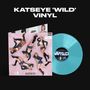 Großer Text: KATSEYE 'WILD' VINYL. Eine blaue Schallplatte und ein Cover mit mehrfacher Frau in Denim-Outfit, rosa Hintergrund.
