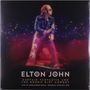 Der Text lautet: "Elton John, Captain Fantastic and the Brown Dirt Cowboy, Live at Midsummer Music, Wembley Stadium 1975." Eine Person in glitzerndem Outfit vor einem funkelnden Hintergrund.