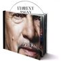 Text: "FLORENT PAGNY". Ein Albumcover mit einem Gesicht im Fokus, das ein geöffnetes Booklet enthält.