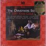 "The Christmas Song" von Nat King Cole. Rot-künstlerischer Rahmen, ein Mann am Kamin, Geschenke liegen herum.
