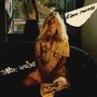 Text: "Kim Carnes", "Mistaken Identity". Eine Frau mit langem blondem Haar sitzt, ein Mann steht am offenen Fenster.