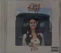 "Lana Del Rey", "Lust for Life". Frau mit Blumen im Haar lächelt vor einem Auto. 