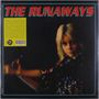 Text: "THE RUNAWAYS". Blonde Person in buntem Glitzeroutfit, dunkler Hintergrund.