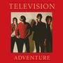 „TELEVISION ADVENTURE“ steht zentriert auf rotem Hintergrund, darunter vier Personen in einer Gruppe.