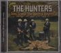 "THE HUNTERS, Teen Scene, The Storm & Beyond" steht über einem Foto von vier Männern in Anzügen mit Hüten auf einem Löwenfell.